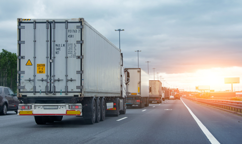 Several trucks travel on a highway