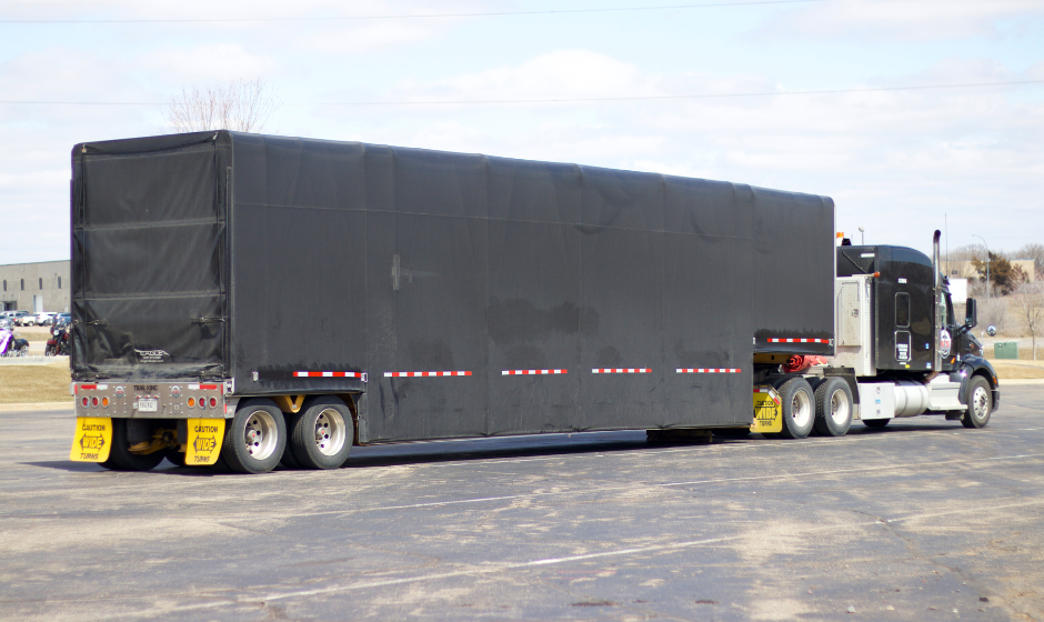 A semi truck with a Conestoga trailer