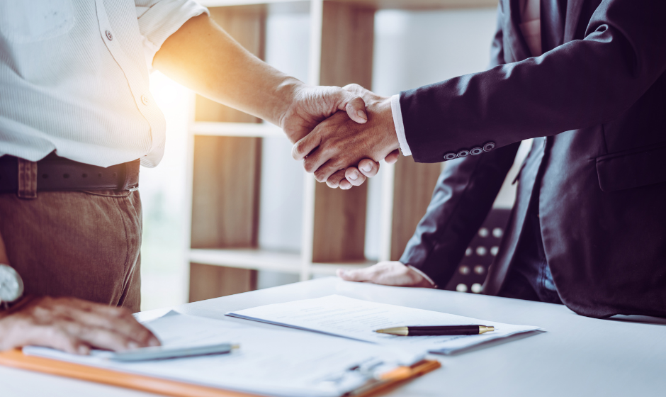 Two people shake hands over a business arrangement