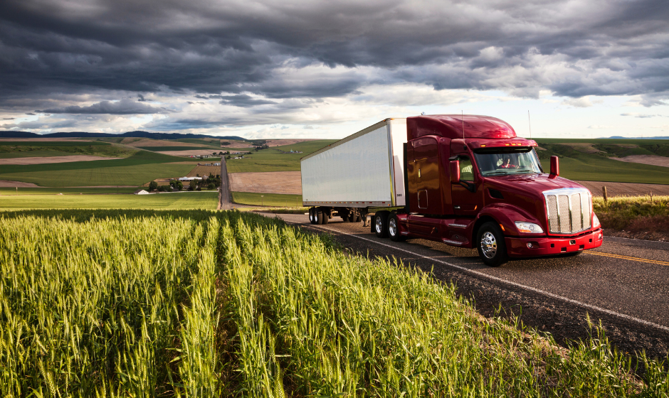 A dry van travels through farmland