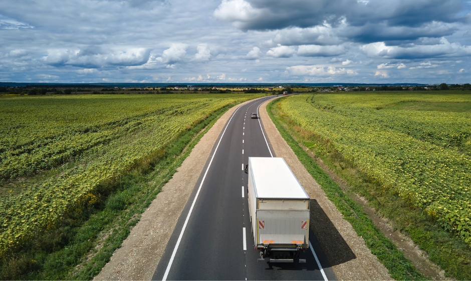 A dry van truck travels through farmland