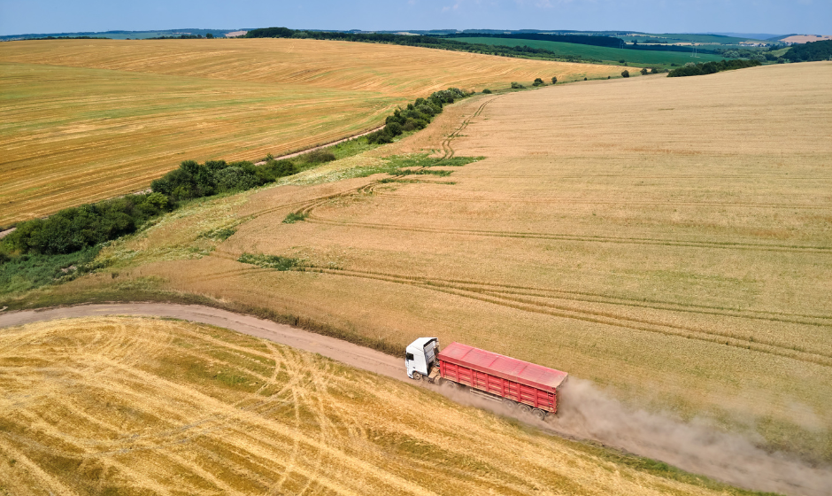 An aerial view of a truck driving through farmland