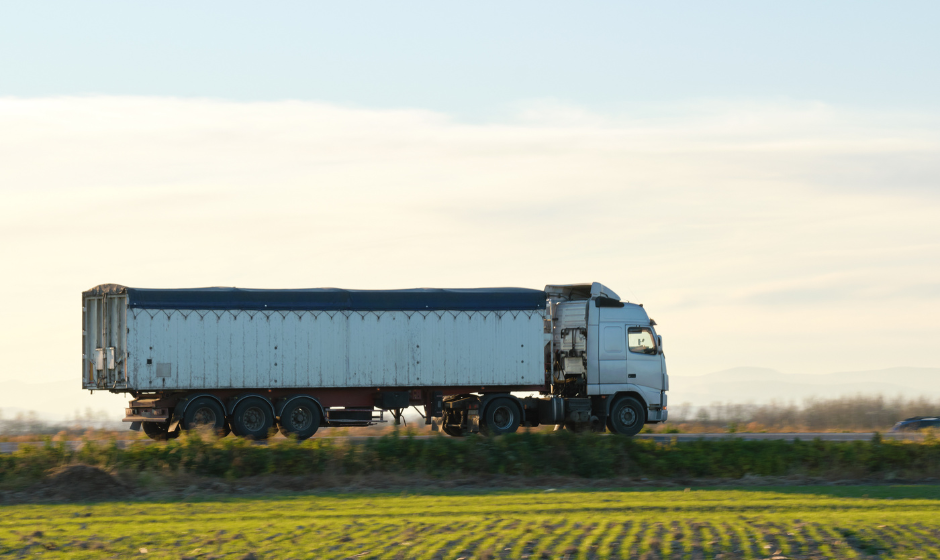 A truck drives through farmland