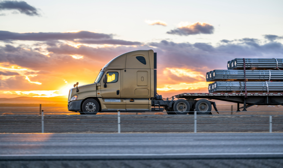 An open-deck truck travels on a highway