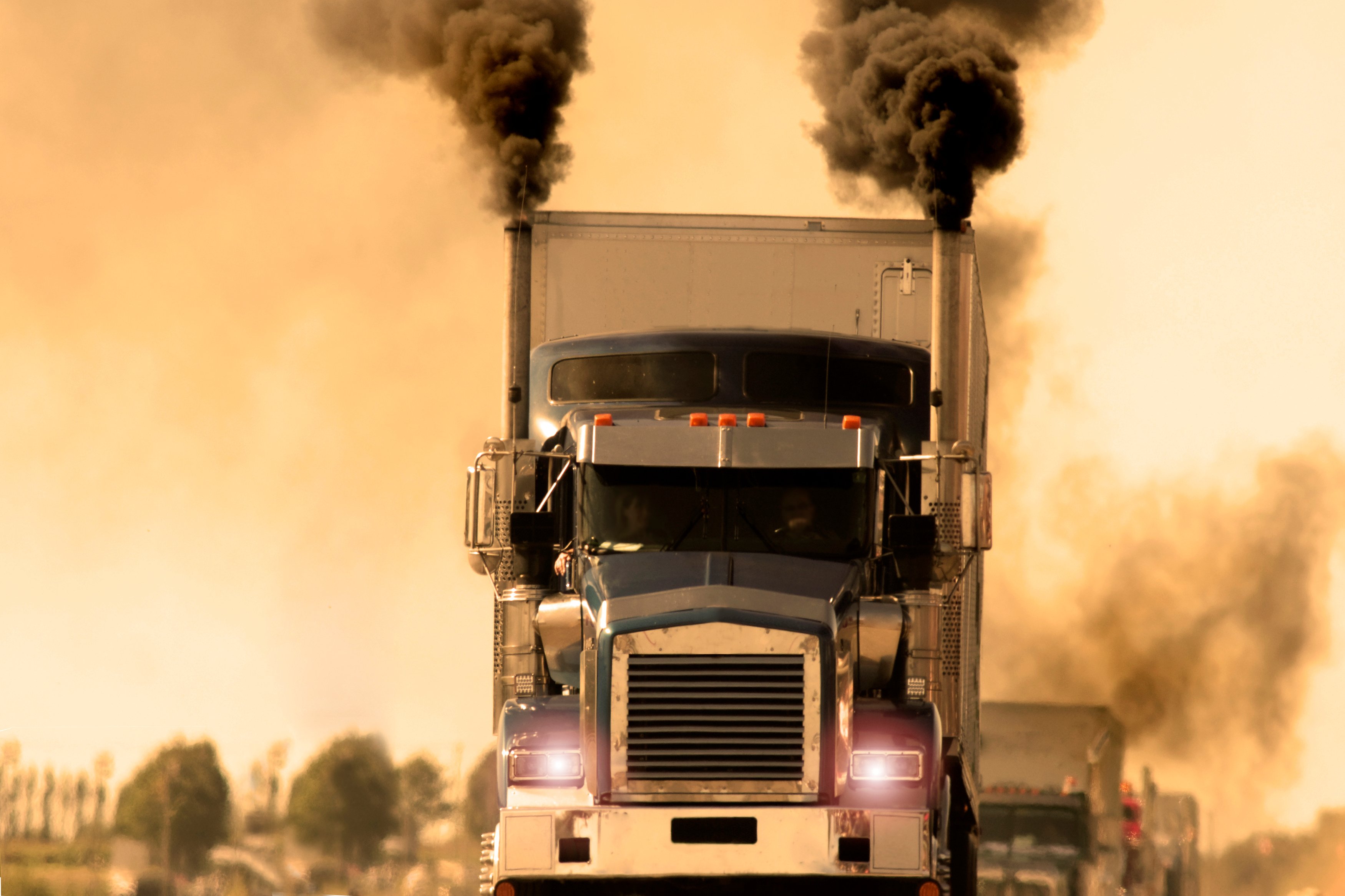 A line of diesel trucks creating dark smoke